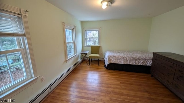 bedroom featuring light wood-style floors and baseboard heating