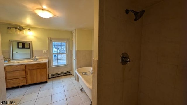 full bathroom with a tub, a wainscoted wall, double vanity, baseboard heating, and tile walls