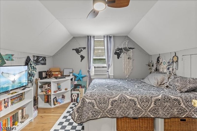 bedroom featuring vaulted ceiling, cooling unit, wood finished floors, and a ceiling fan