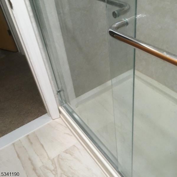 full bathroom featuring a stall shower and marble finish flooring
