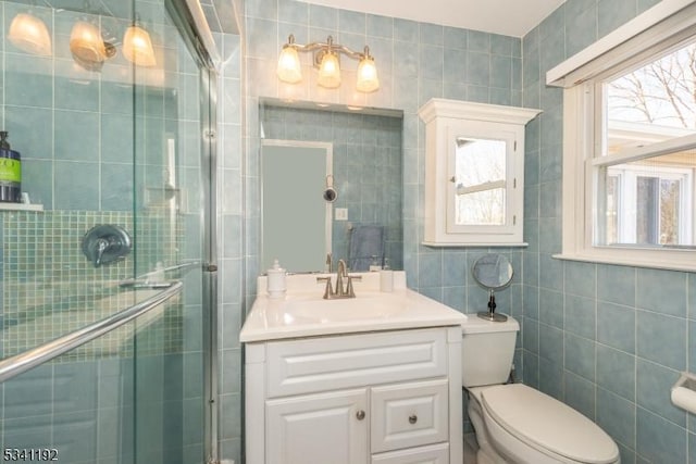 bathroom with a stall shower, a wealth of natural light, and tile walls