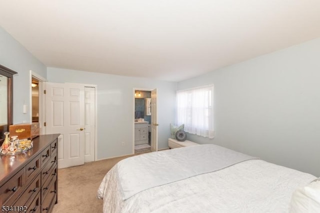 bedroom with light colored carpet and ensuite bath