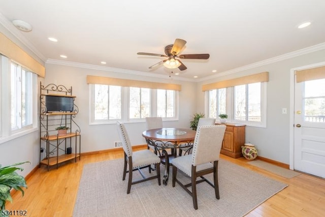 dining area featuring a healthy amount of sunlight, light wood-style floors, baseboards, and ornamental molding