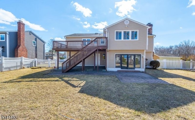 back of house with a deck, a fenced backyard, stairs, a yard, and a chimney