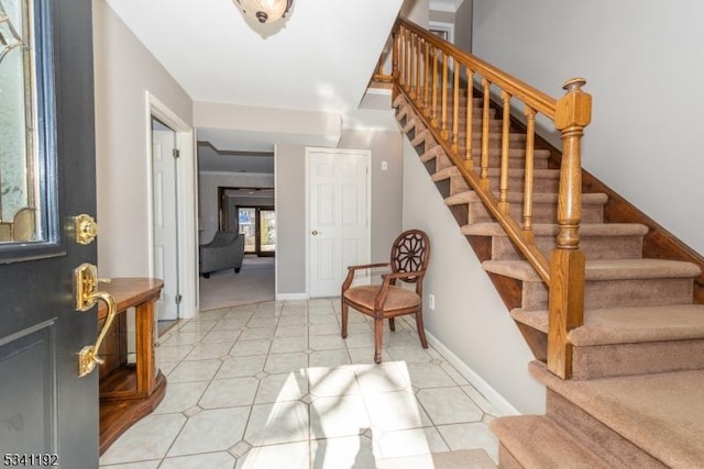 entrance foyer featuring light tile patterned floors, stairs, and baseboards