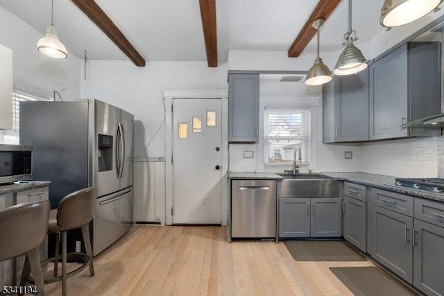 kitchen featuring backsplash, appliances with stainless steel finishes, light wood-type flooring, and gray cabinetry