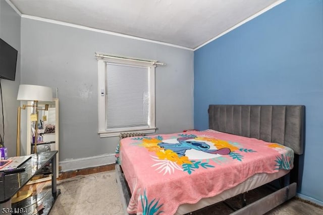 bedroom with crown molding, baseboards, and wood finished floors