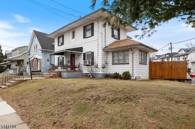 view of front of house with a front yard and fence