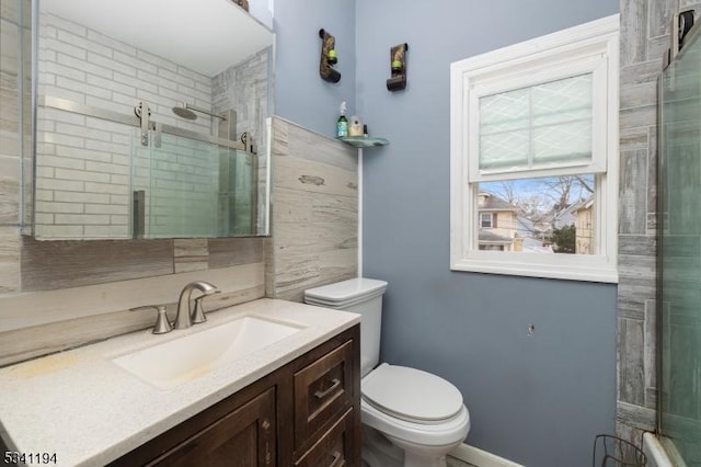 bathroom with tiled shower, toilet, and vanity