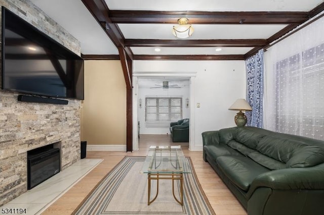 living room featuring wood finished floors, beamed ceiling, a ceiling fan, and baseboards