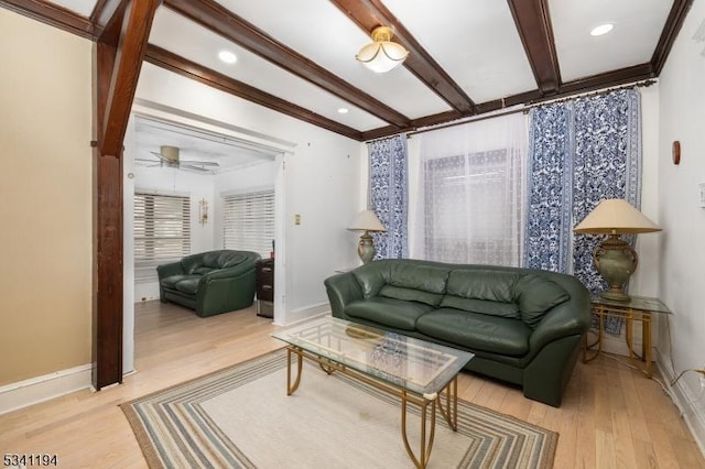 living room featuring beamed ceiling, baseboards, and light wood-style flooring