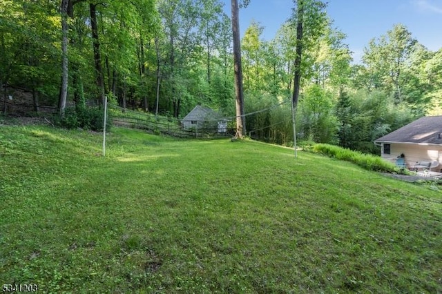 view of yard with a wooded view and fence