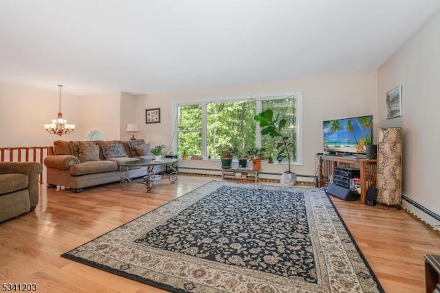 living room featuring a notable chandelier, baseboard heating, and wood finished floors