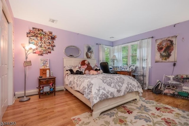 bedroom with light wood finished floors and visible vents