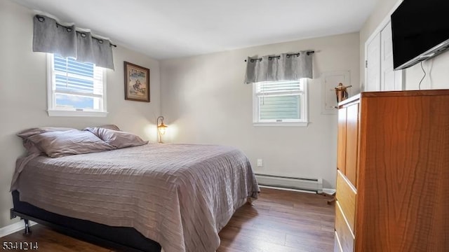 bedroom featuring a baseboard radiator, wood finished floors, and baseboards