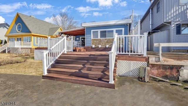 rear view of property featuring covered porch