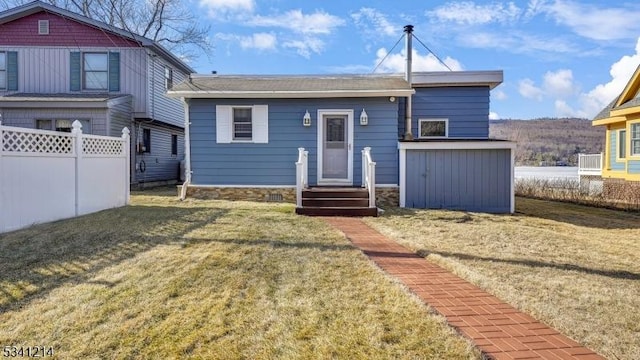 view of front of property with a front yard and fence