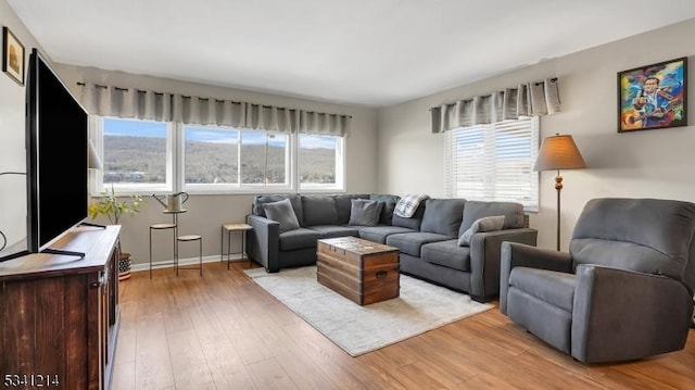 living area featuring light wood-type flooring and baseboards