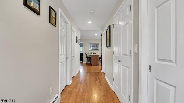 hall featuring baseboards, recessed lighting, and light wood-style floors