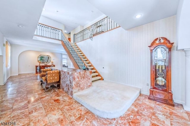 stairs with baseboards, arched walkways, and recessed lighting