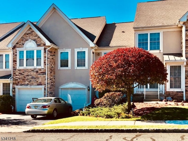 multi unit property featuring an attached garage, stone siding, concrete driveway, and stucco siding