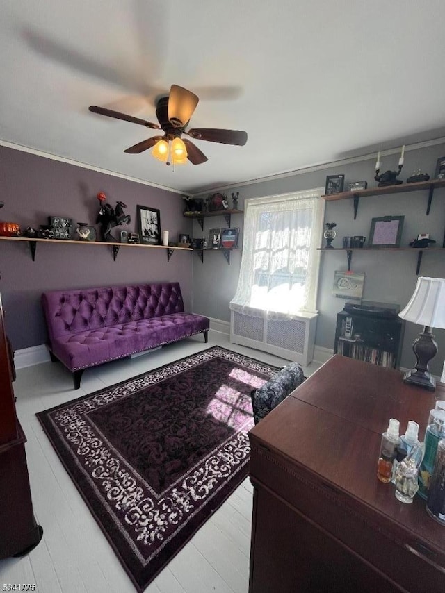 living area with crown molding, ceiling fan, and baseboards