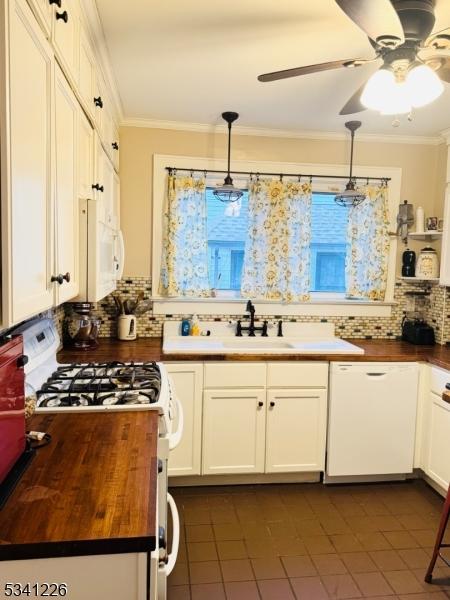 kitchen featuring butcher block countertops, white appliances, white cabinets, and crown molding