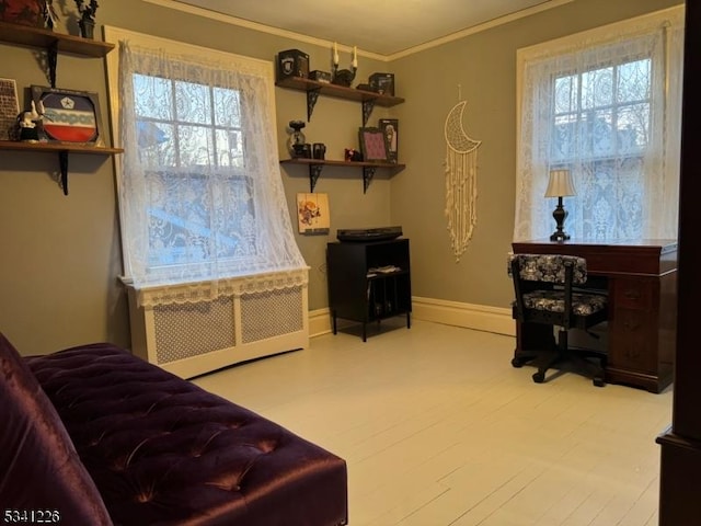 sitting room featuring baseboards, radiator, wood finished floors, and crown molding