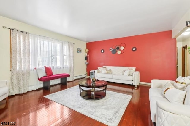 living room featuring an accent wall, wood finished floors, and baseboards