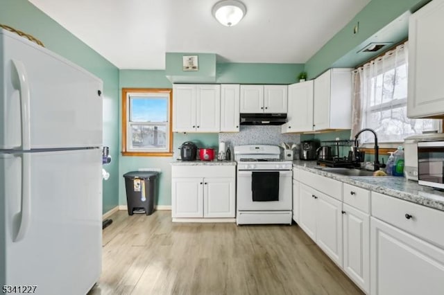 kitchen featuring white appliances, under cabinet range hood, white cabinetry, and a sink