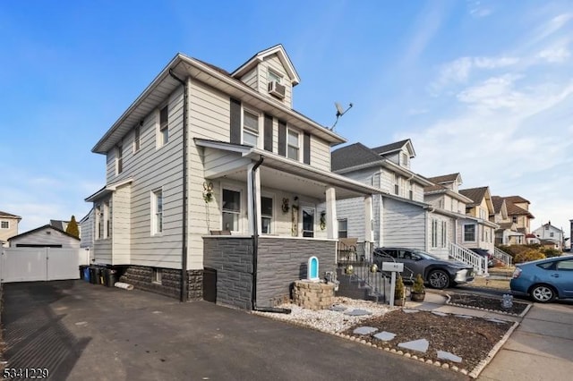 traditional style home featuring aphalt driveway, cooling unit, and a residential view