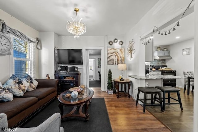 living room with a notable chandelier and wood finished floors