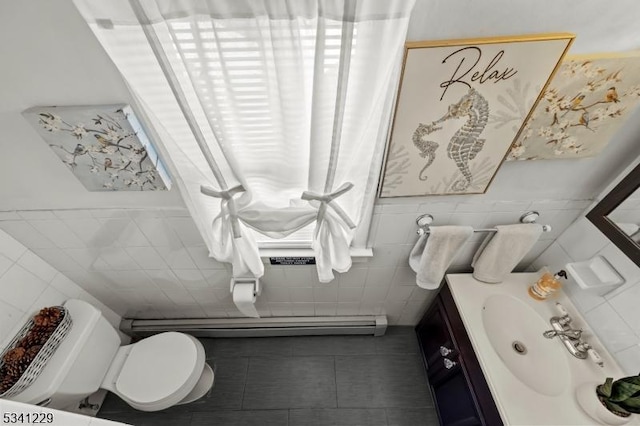 half bathroom featuring toilet, vanity, tile walls, and tile patterned floors