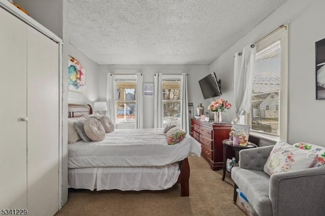 carpeted bedroom featuring a textured ceiling and a closet