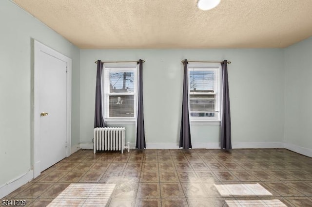 empty room with radiator heating unit and a textured ceiling