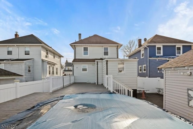 rear view of property with fence and a wooden deck