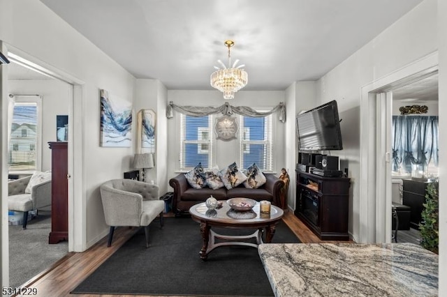 living room with wood finished floors and an inviting chandelier