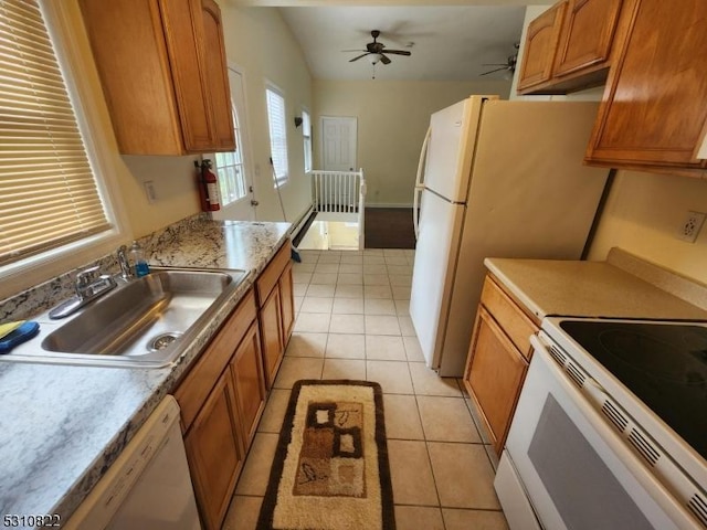 kitchen featuring white appliances, light tile patterned floors, brown cabinetry, light countertops, and a sink