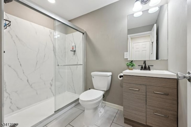 full bath featuring toilet, a marble finish shower, baseboards, and vanity