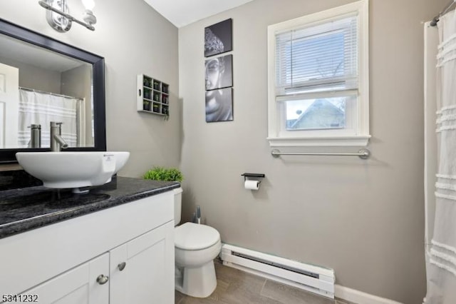 full bathroom featuring toilet, a baseboard radiator, vanity, and baseboards