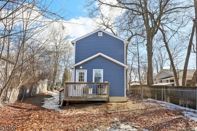 rear view of property featuring a deck and fence