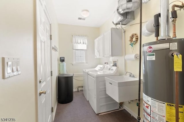 clothes washing area featuring cabinet space, visible vents, gas water heater, washing machine and dryer, and a sink