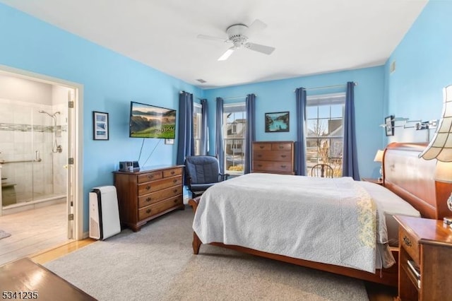 bedroom with wood finished floors, ceiling fan, and ensuite bathroom