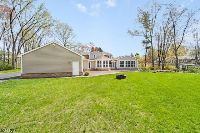 rear view of house with a patio and a lawn