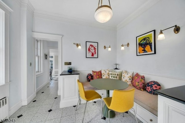 dining area with crown molding, baseboards, breakfast area, radiator heating unit, and granite finish floor