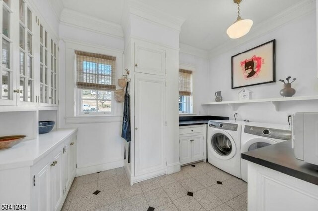 clothes washing area featuring cabinet space, washer and dryer, crown molding, and baseboards