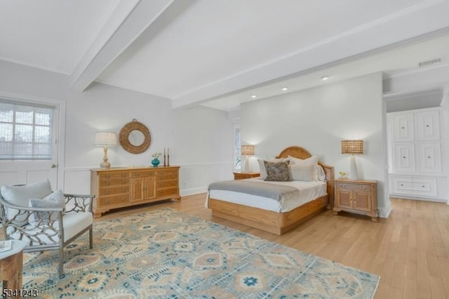 bedroom with visible vents, beam ceiling, baseboards, and light wood-style flooring