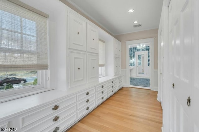 interior space featuring visible vents, recessed lighting, ornamental molding, light wood-style floors, and wainscoting