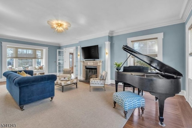 living room with crown molding, a fireplace with raised hearth, and baseboards