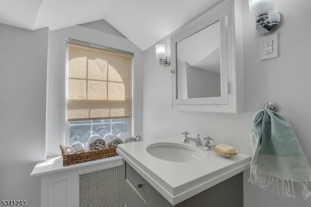 bathroom with vanity and lofted ceiling